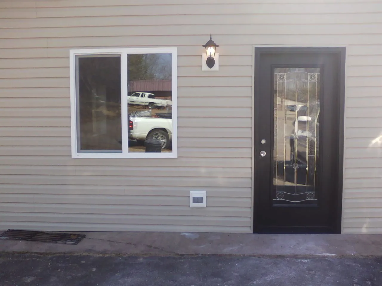 New siding, window and entry door on the side of an addition in Rockville Centre