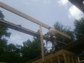 Carpenter setting a ridge beam over a new addition frame — Ice Dam Removal by Roofing Brothers in Rockville Centre