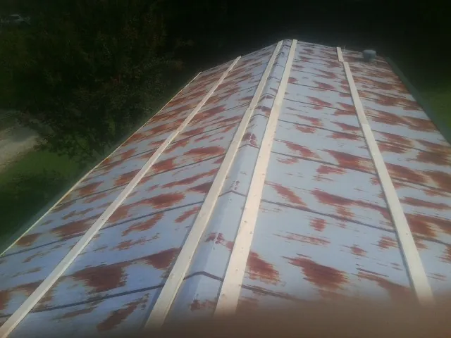 Rusted metal roof panels with new wood purlins before replacement — Storm Damage Roof Repair in Rockville Centre by Roofing Brothers