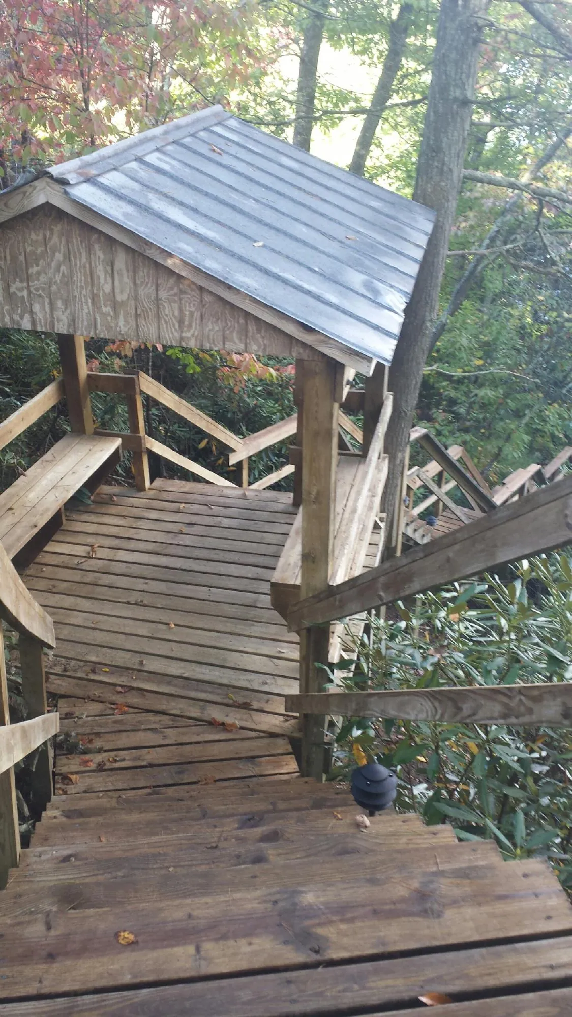 Metal roofed shelter over wooden steps on a wooded walkway — Skylight Repair & Installation work by our crew in Rockville Centre
