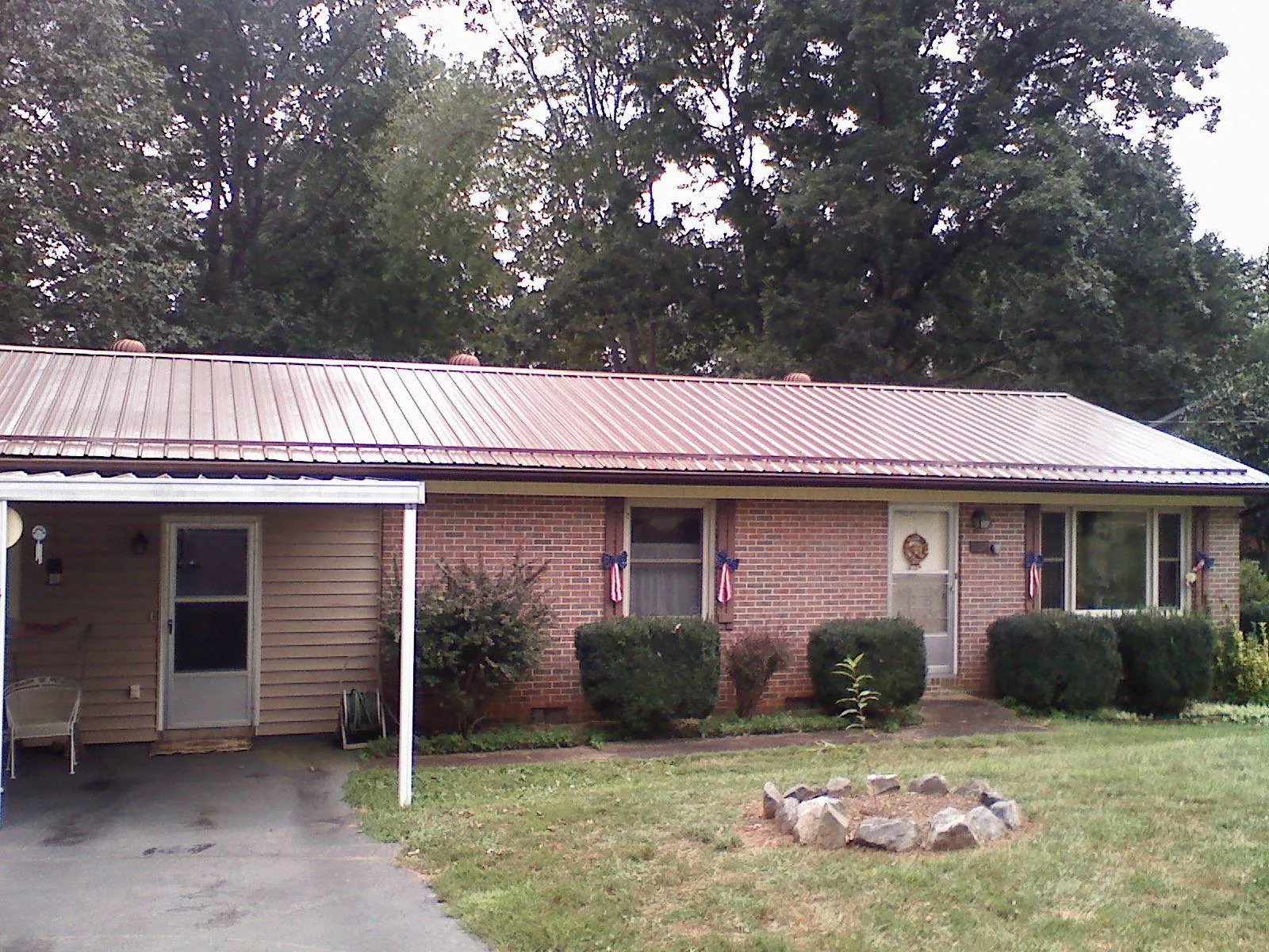 Bronze metal roof and carport on a brick ranch home — Roof Repair work by our crew in Rockville Centre